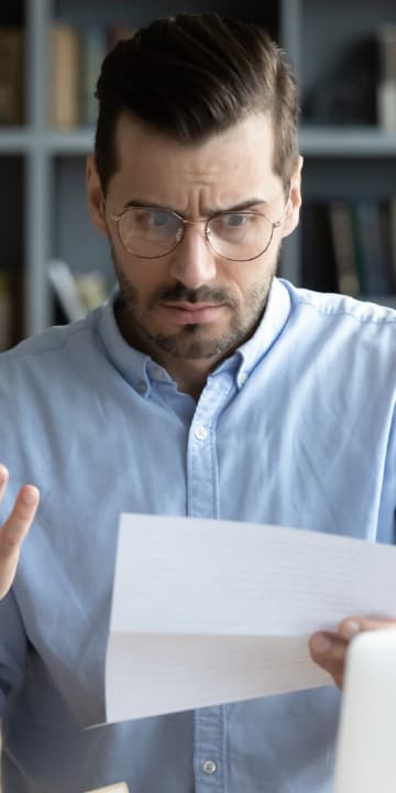 Trabajador revisando notificación de rechazo de la ART con documentación médica